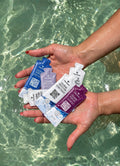 Hands holding TRIHARD sachets in pool water