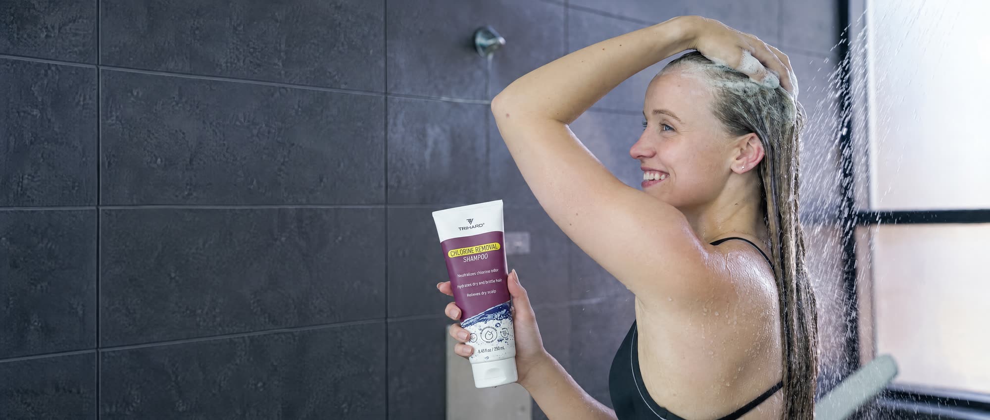 Swimmer washing her hair in the shower with TRIHARD Chlorine Removal Shampoo